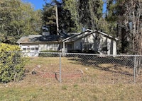 a house with a chain link fence in front of it