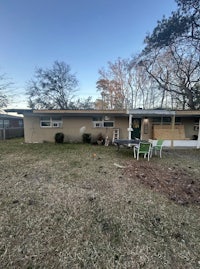 a house with a lawn and chairs in the yard