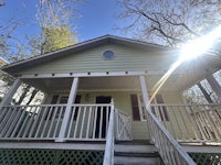 a house with a porch and a sun shining on it