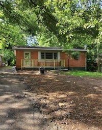 a house in the woods with a driveway