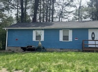 a blue house in the middle of the woods